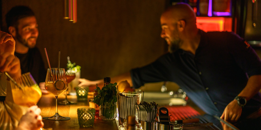 Das Bild zeigt einen Bartender welcher sich im Restaurant in Saarburg mit einem Gast unterhält