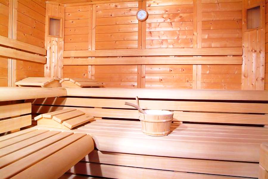 In einer Sauna zum Entspannen nach einer Massage steht ein Aufgusseimer bereit. 